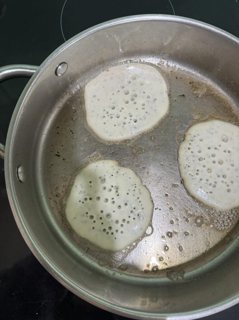 Pancakes frying on frypan.