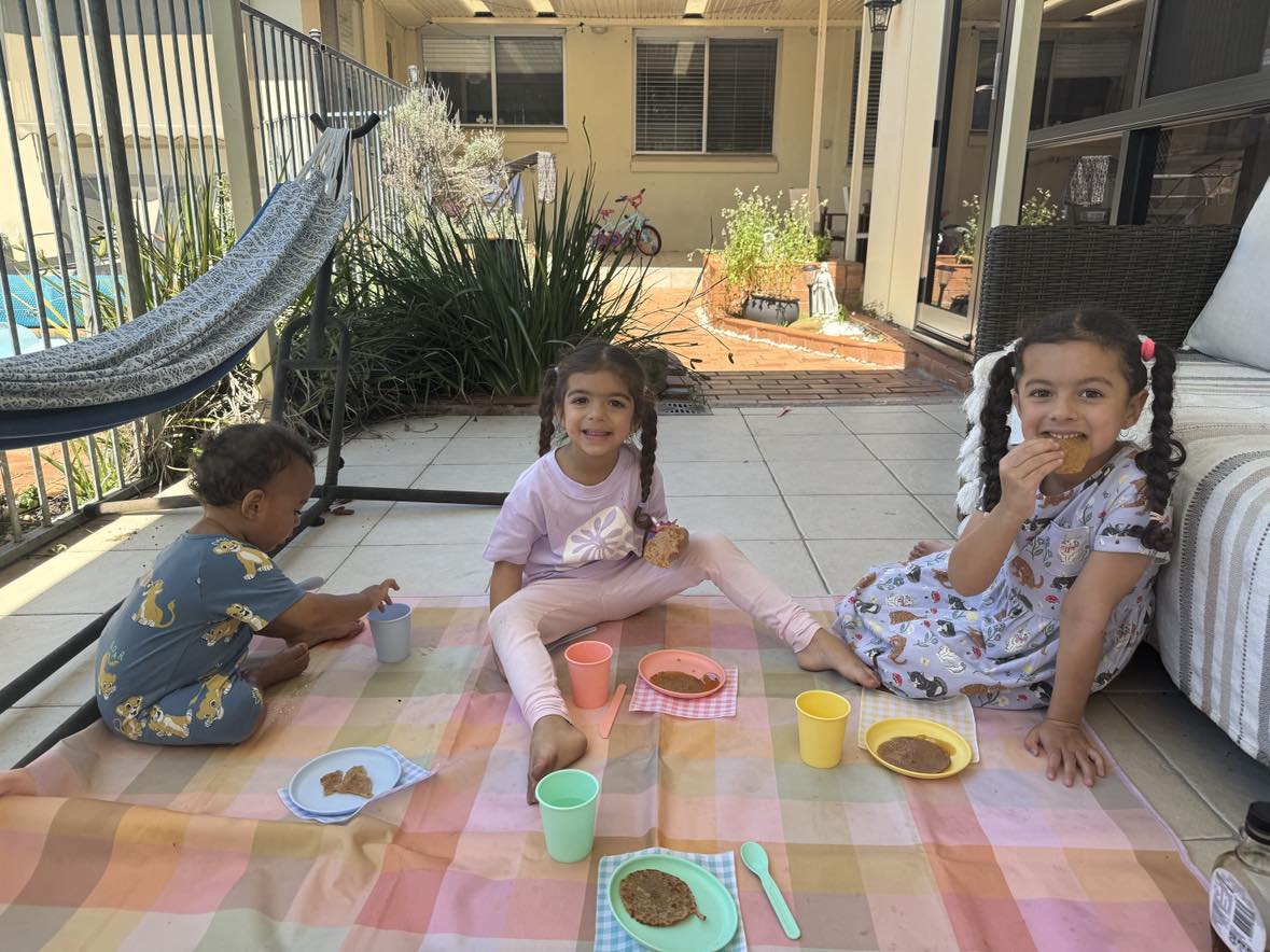 My three children having an afternoon picnic in our backyard during our homeschool break.