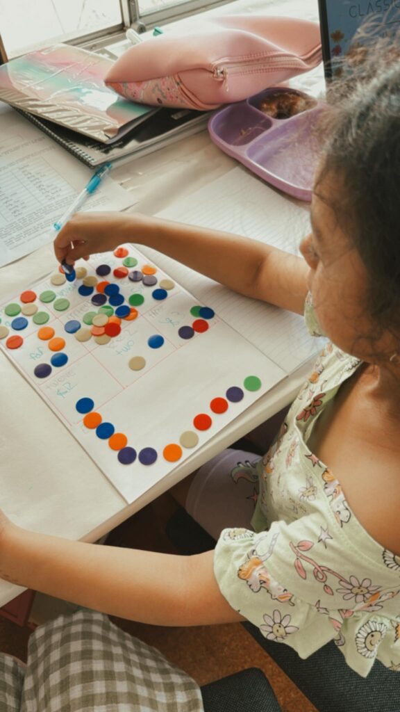 6 year old daughter completing Maths lesson using counters.