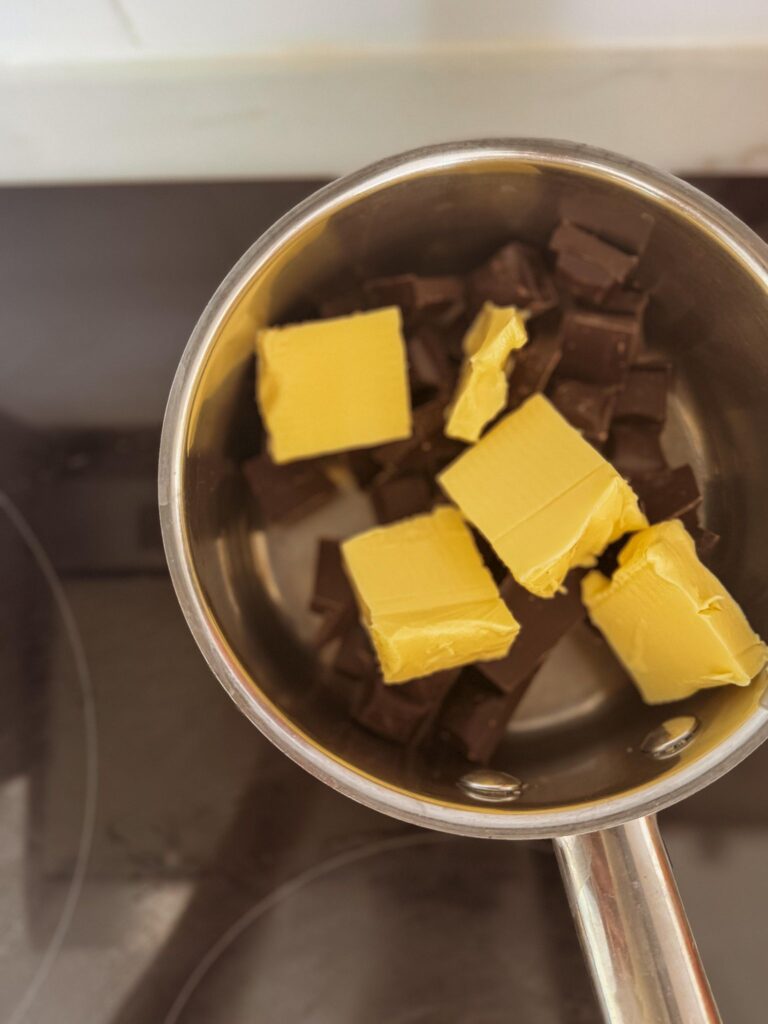 Healthy and Irresistible Chocolate Nut Bars: chocolate and butter melting over stove top.