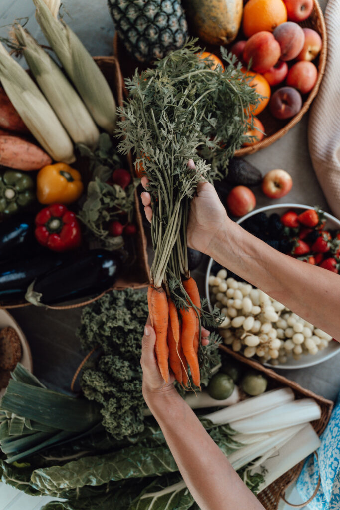 How to support your gut after antibiotics use during labour: carrots over a table of produce.