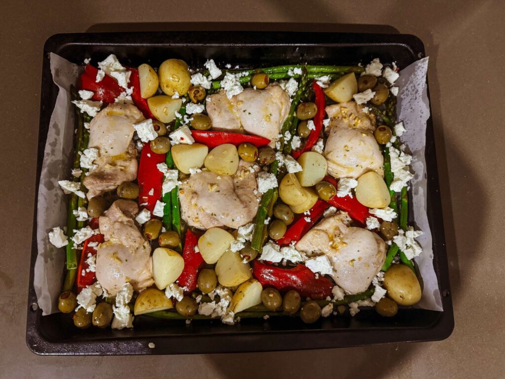 Mediterranean Chicken Tray Bake olives and feta cheese added to tray