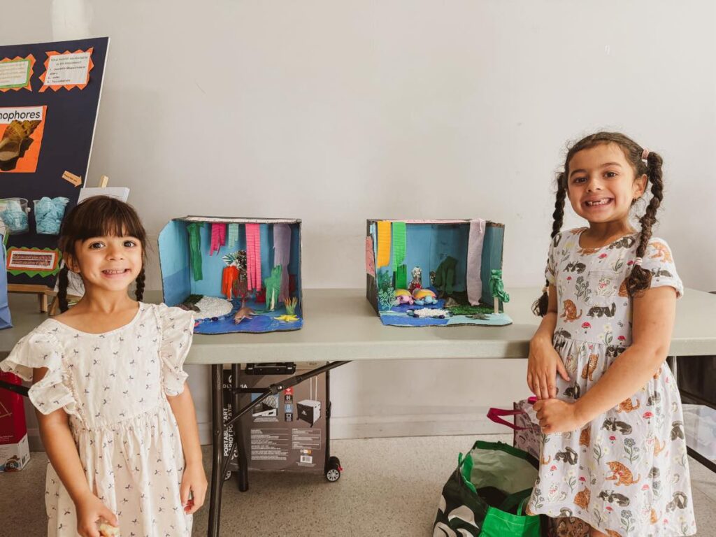 Our first year of homeschooling in a nutshell: two sisters with their sea creature dioramas