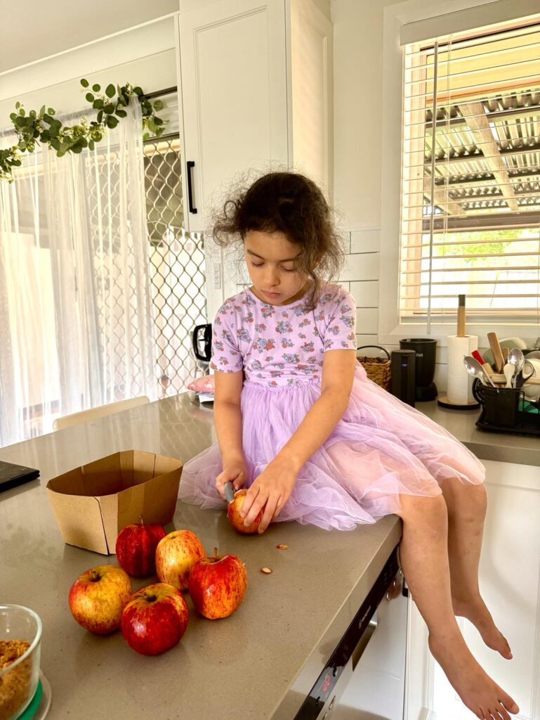 Healthy Homemade applesauce for kids: daughter peeling apples